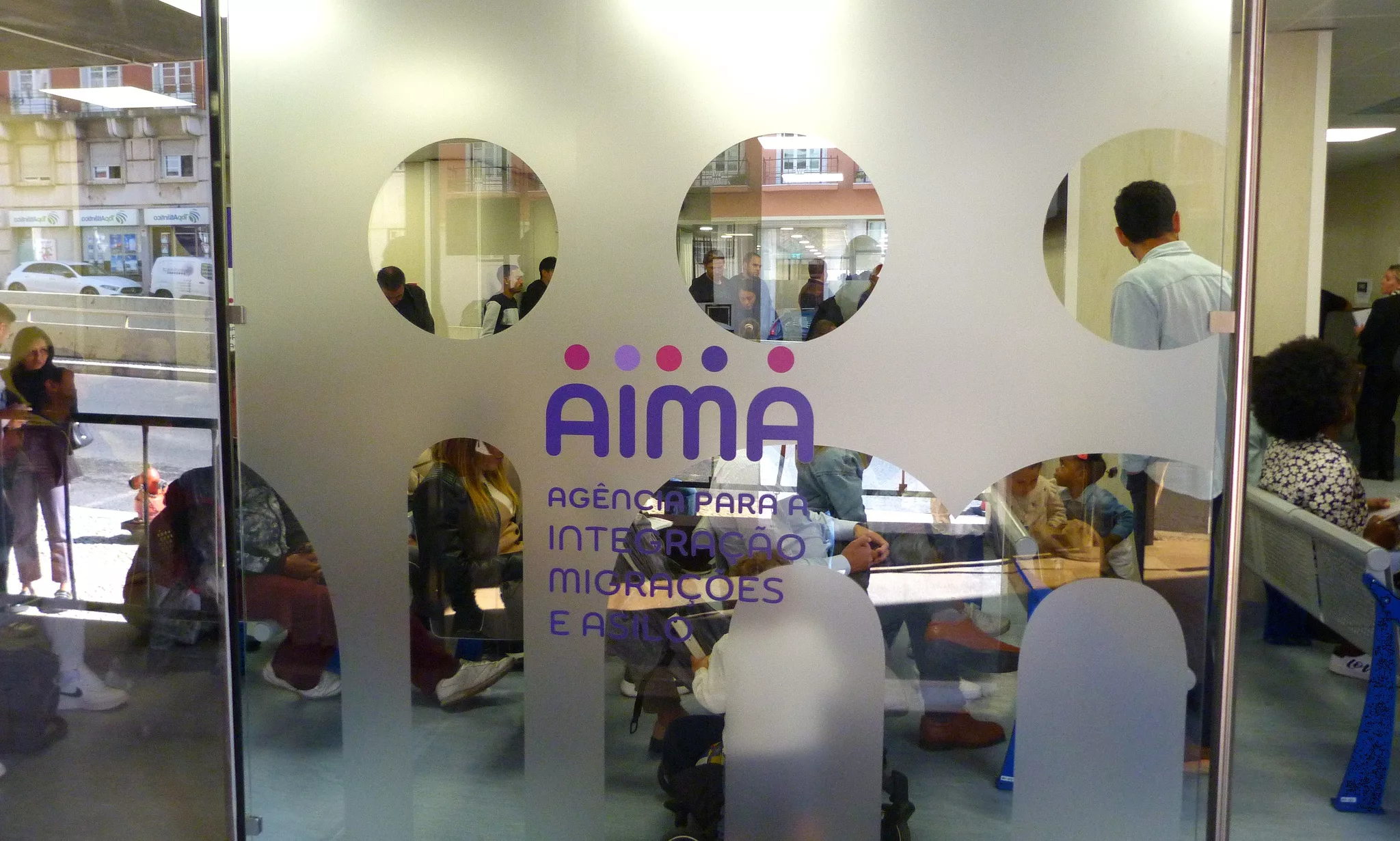 Applicants waiting inside and outside an AIMA immigration office in Portugal